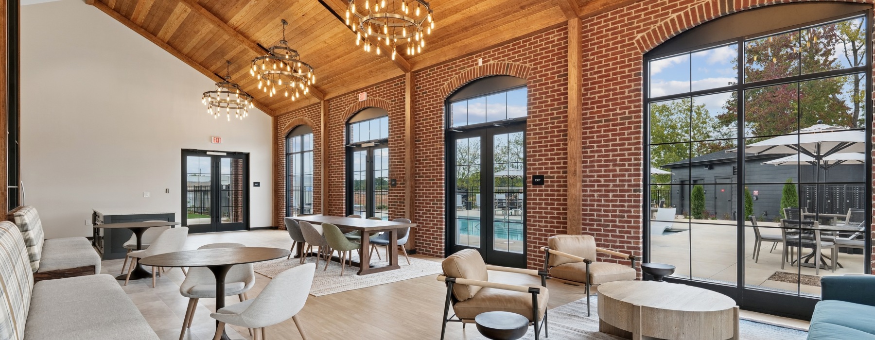 Resident lounge with tables and chairs next to the pool at Sablewood new townhomes in Charlotte, NC for rent.